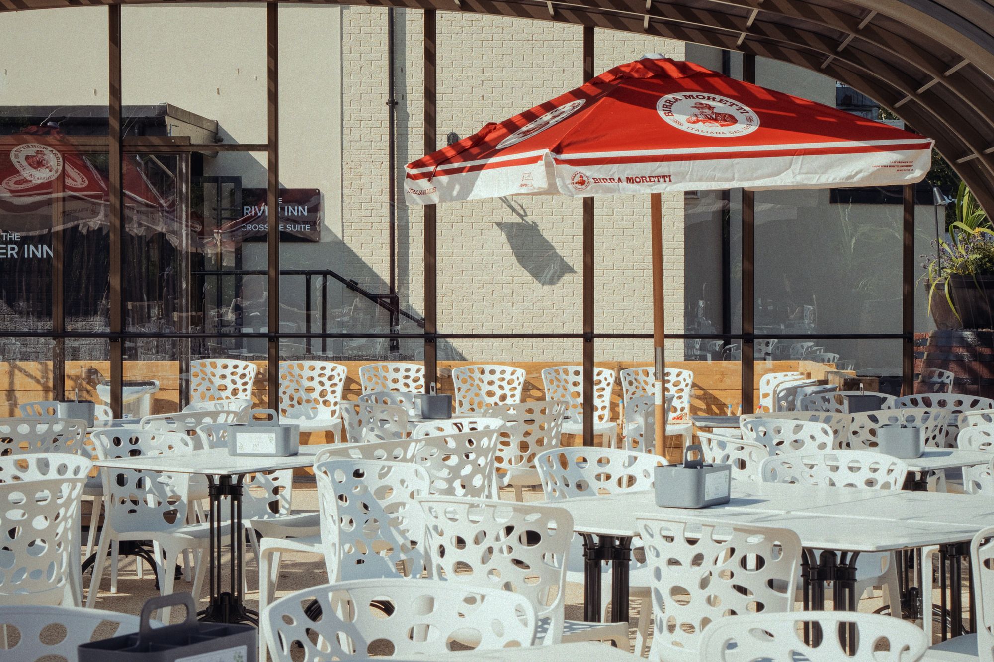 Tables and chairs laid out under the glasshouse roof